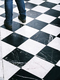 Low section of man standing on checked floor