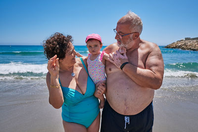 A couple of grandparents with their granddaughter on vacation at the beach. vacation concept