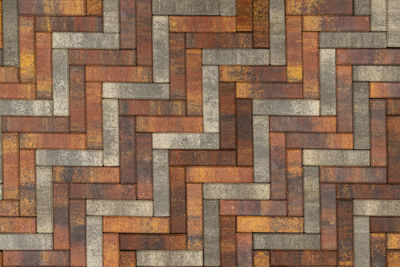 Texture and full frame background of brown, yellow and grey parquet artificial stone pavement