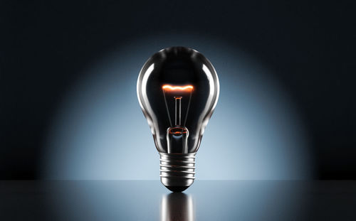 Close-up of light bulb against black background