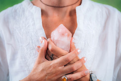 Self-worth meditation concept. hands holding a rose quartz crystal, meditating