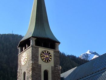 Low angle view of clock tower against sky during winter