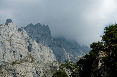 Scenic view of rocky mountains against cloudy sky