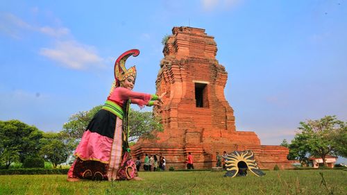 Statues on field against sky