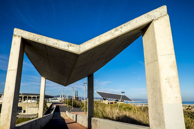 Narrow pathway against blue sky