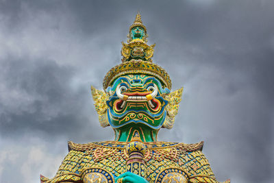 Low angle view of statue against temple building against sky