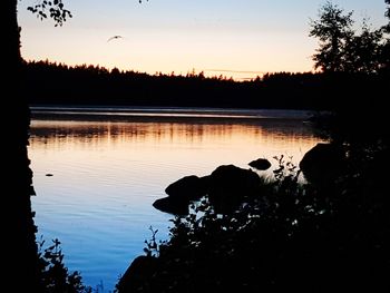 Scenic view of lake against sky at sunset