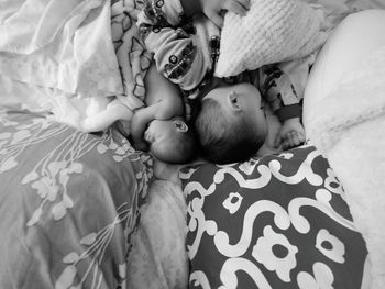 High angle view of siblings sleeping on bed at home