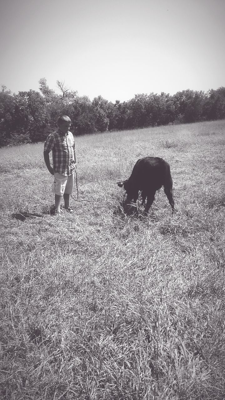 SIDE VIEW OF TWO PEOPLE WALKING ON FIELD