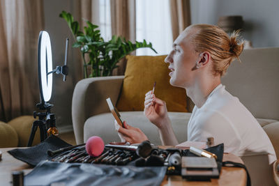 Make-up artist through smart phone vlogging in front of ring light