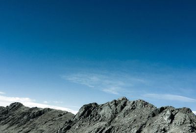 Low angle view of mountain against blue sky