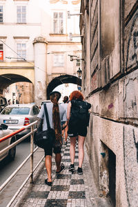 Rear view of people standing on road in city