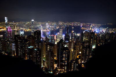 Illuminated cityscape against sky at night