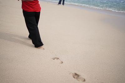 Low section of person standing on beach