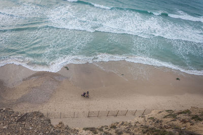 High angle view of people walking on beach