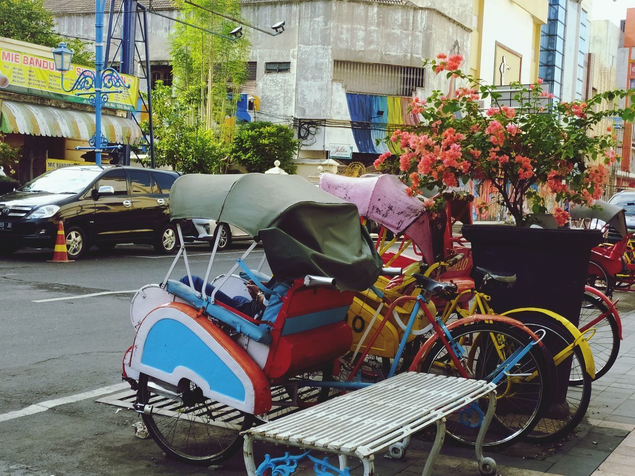 BICYCLE PARKED ON STREET AGAINST BUILDINGS