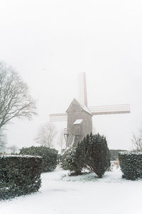 Built structure on snow covered field against sky