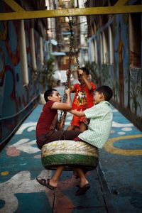 Rear view of father and girl sitting on floor