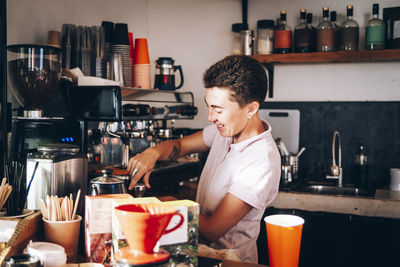 Female barista preparing coffee while working at cafe