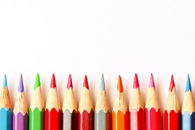 Close-up of multi colored pencils against white background