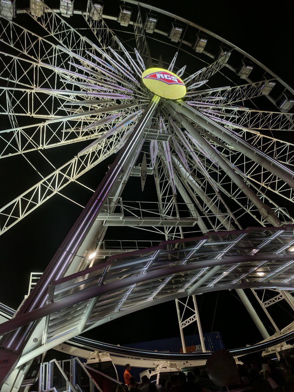 LOW ANGLE VIEW OF ILLUMINATED FERRIS WHEEL AT NIGHT