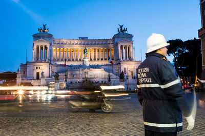 Man standing on road against historic building