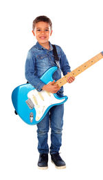 Portrait of a boy playing guitar against white background