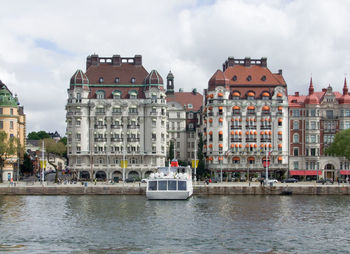 Boats in river with buildings in background