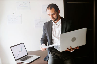 Businessman holding laptop at office