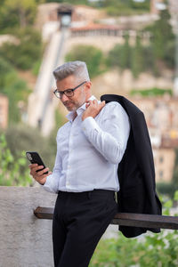 Businessman using mobile phone while standing outdoors