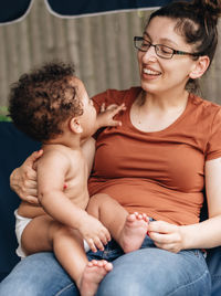 Mother and baby girl sitting on sofa