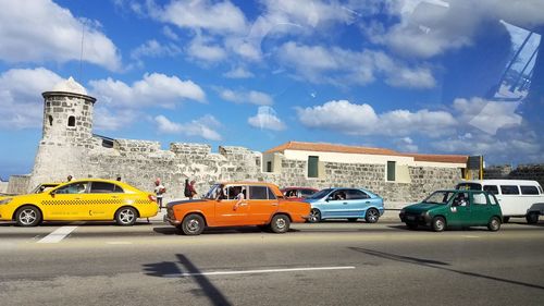 Cars on street against sky