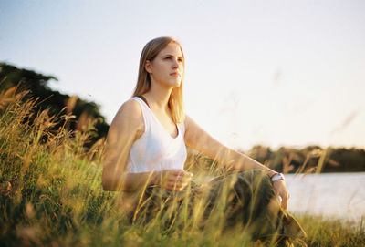 Young woman on field against sky