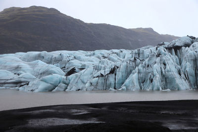 Scenic view of frozen lake against mountain range