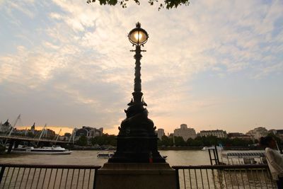 Bridge over river against cloudy sky