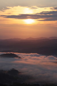 Scenic view of dramatic sky over landscape during sunset