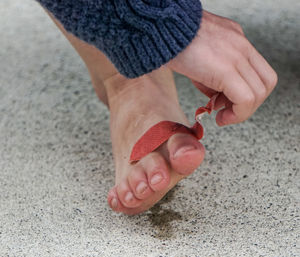 Low section of woman applying bandage on leg