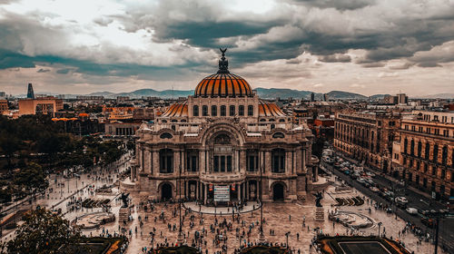 Buildings in city against cloudy sky