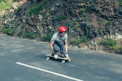 Teenage boy skateboarding on road