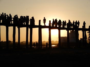 Silhouette people against clear sky during sunset crossing the u-bein bridge in mandalay, myanmar. 