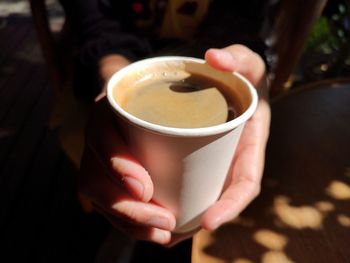 Close-up of hand holding coffee cup