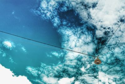 Low angle view of electricity pylon against blue sky