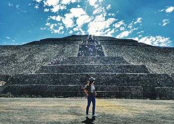 Low angle view of a person standing on stone structure