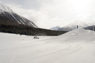 A sports car on the ice speeding and burning tires in winter in a snowy ice piste...