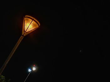 Low angle view of illuminated street light against sky at night