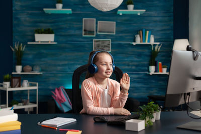 Young woman using phone while sitting on table