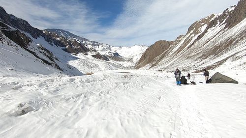 People on snowcapped mountain against sky