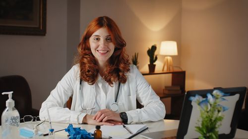 Beautiful italian female doctor in uniform smiles in her office