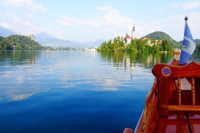 Traditional boat sailing in lake against sky