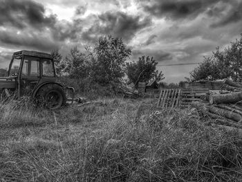 View of field against cloudy sky